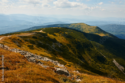 Fototapeta Naklejka Na Ścianę i Meble -  Mountain landscape. Scenic view of mountain peaks, slopes, hills and valleys covered with grass and trees. Panoramic view. Natural scenery