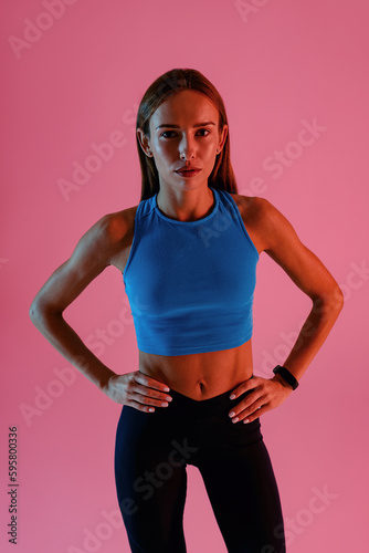 Beautiful fitness woman wearing sportswear posing over studio background. High quality photo