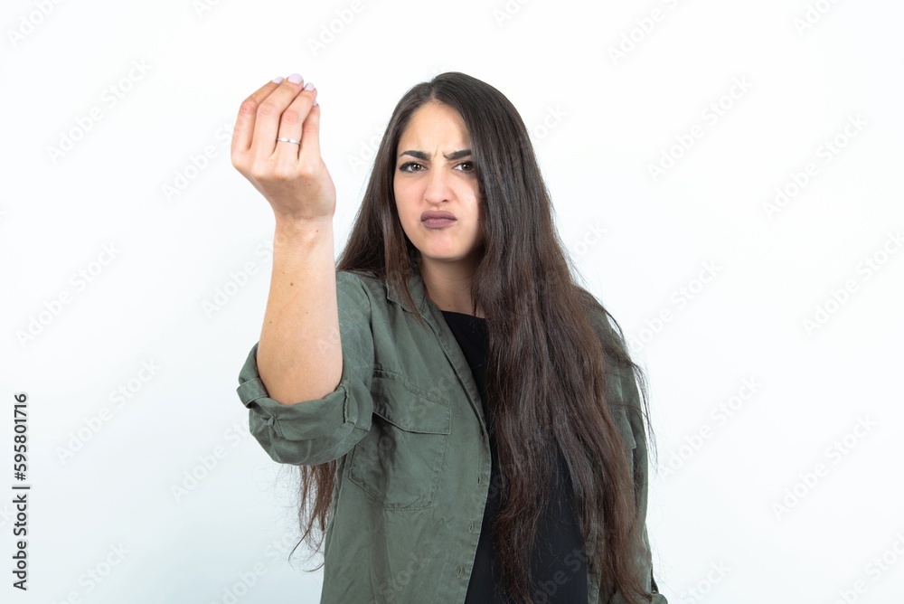 young brunette woman wearing casual clothes over white studio background angry gesturing typical italian gesture with hand, looking to camera young brunette woman wearing casual clothes over white studio background angry gesturing typical italian gesture with hand, looking to camera