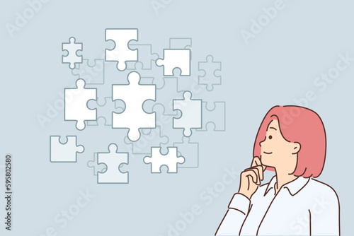 Thoughtful businesswoman looking at puzzle pieces choosing right tactics to solve business problems