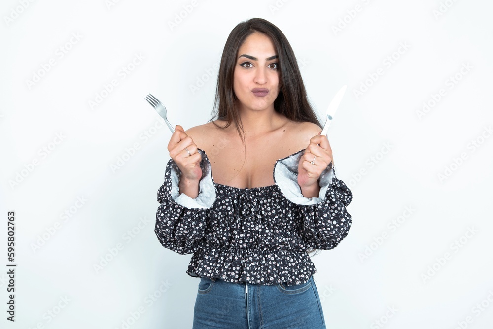 hungry young brunette woman wearing a blouse over white studio background holding in hand fork knife want tasty yummy pizza pie hungry young brunette woman wearing a blouse over white studio background holding in hand fork knife want tasty yummy pizza pie