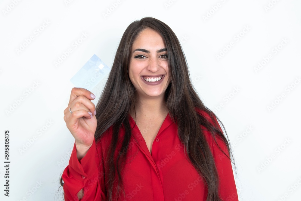 Photo of happy cheerful smiling positive Young brunette woman wearing red shirt over white studio background recommend credit card Photo of happy cheerful smiling positive Young brunette woman wearing red shirt over white studio background recommend credit card