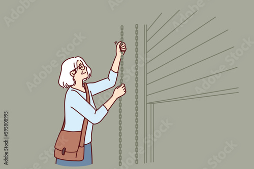 Elderly woman closes shop to store after end of working hours and departure of customers from store or cafe. Grey-haired female small business owner ends working day by closing doors to trading floor 