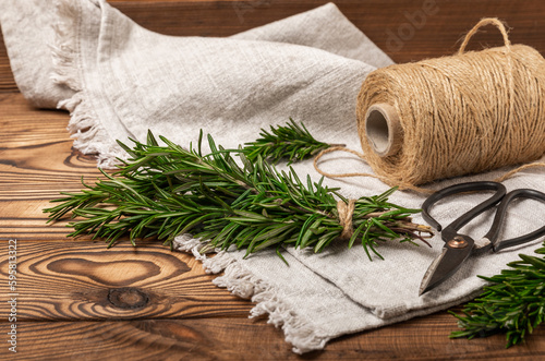 Branches of fresh rosemary on a brown texture background. Spicy spices. Seasoning for meat and fish. Cooking concept. RECEPT. Close-up. place for text. photo