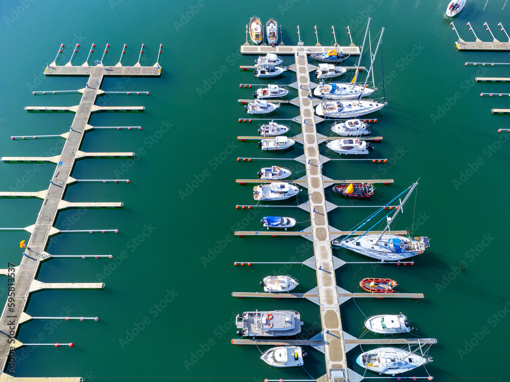 Aerial view of the many white yachts and sailboats moored in the marina on the turquoise water, summer season. Harbor in Poland Gdynia.