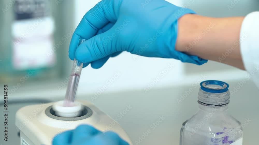 mixing of the chemical sample in a glass measuring cup with the help of an automatic machine mixing of the chemical sample in a glass measuring cup with the help of an automatic machine