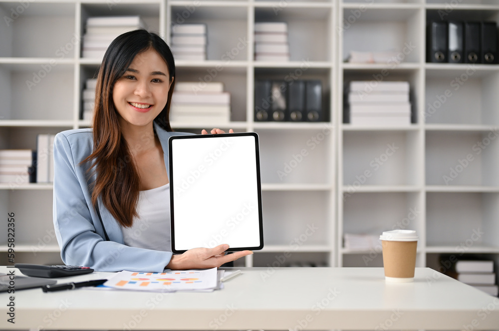 Charming Asian businesswoman holding a tablet white screen mockup Charming Asian businesswoman holding a tablet white screen mockup