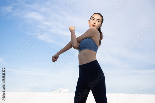 Fototapeta Naklejka Na Ścianę i Meble -  Young beauty Asian woman stretching workout outdoor rooftop. She warming up
