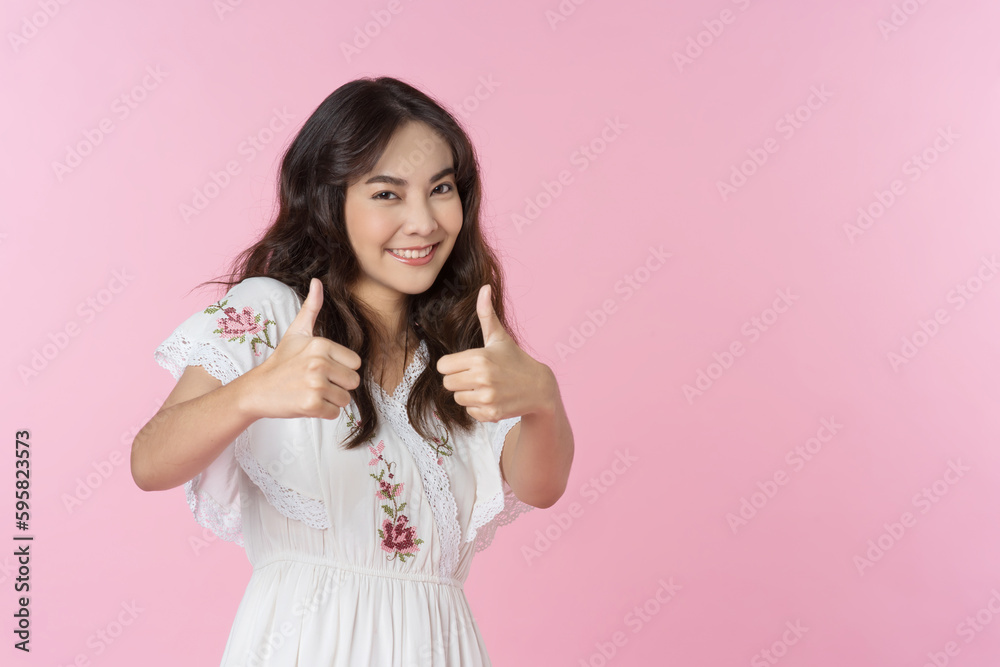 Young Asian woman showing two hands with thumbs up on isolated pink background Young Asian woman showing two hands with thumbs up on isolated pink background