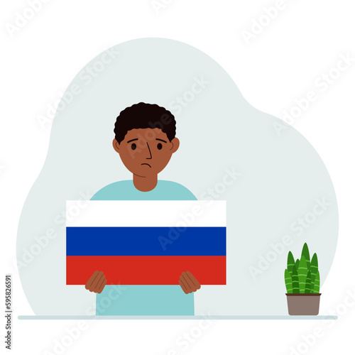 A little boy is holding a Russian flag. The concept of demonstration, national holiday or patriotism. Nationality.