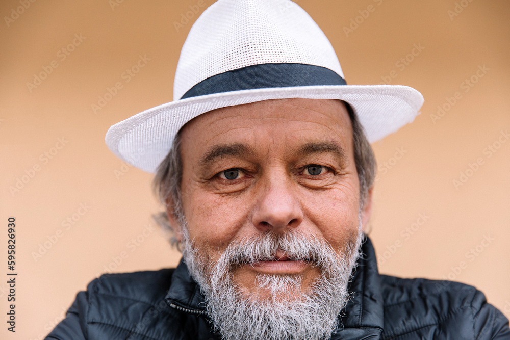 Portrait of a confident, handsome, mature man, pensioner, grandfather near his house, anti aging activities