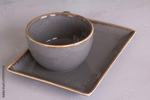 gray clay coffee cup with saucer on the table
