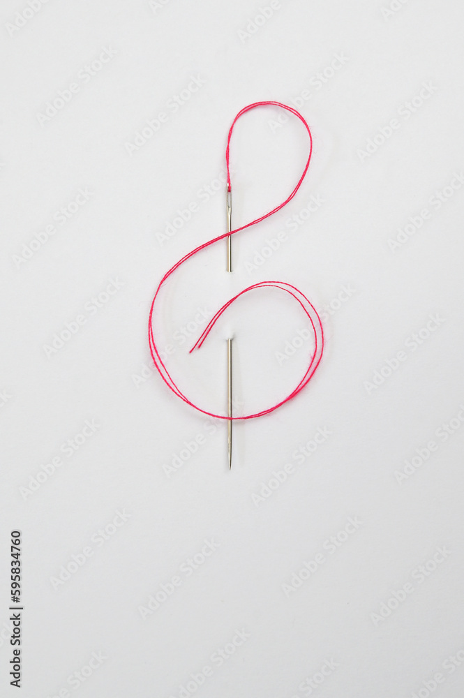Red cord through the Needle In The Form Of A Treble Clef