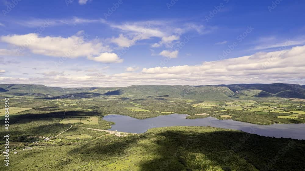 Hyperlapse showcasing the plains of Huejucar, Jalisco, featuring a lake or reservoir, with few clouds in the sky creating a shadow spectacle on the green plains and water. Hyperlapse showcasing the plains of Huejucar, Jalisco, featuring a lake or reservoir, with few clouds in the sky creating a shadow spectacle on the green plains and water.