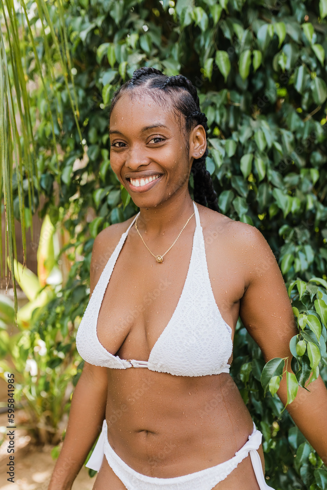Cheerful black tourist near lush bush