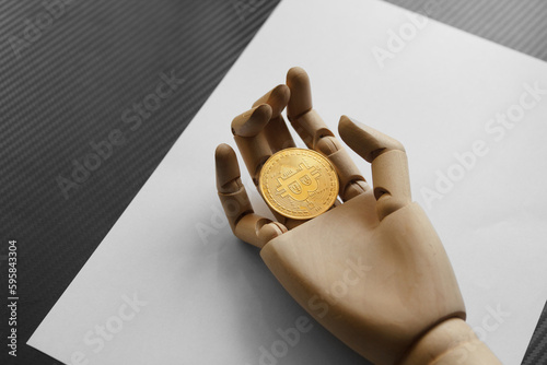 Artificial hand holding one bitcoin on white paper background. Virtual money concept and Financial growth concept. Trading Mining of bitcoins.