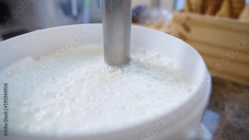 Ice cream making in the process - Professional blender in a bucket for churning ice cream with waffles in the background. High quality 4k footage