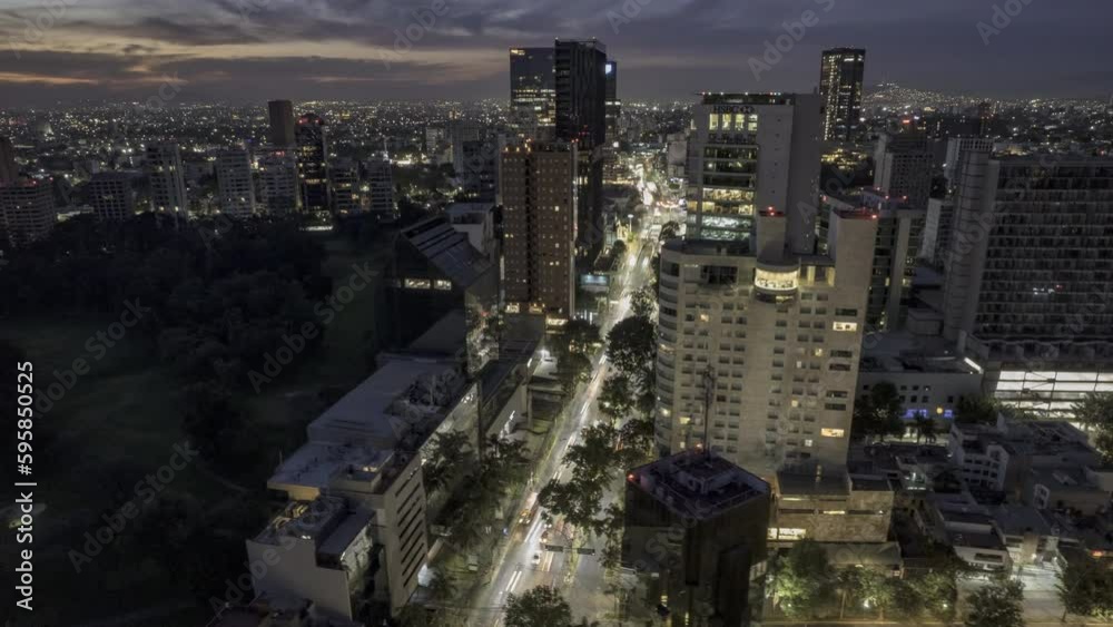 Hyperlapse revealing the Punto Sao Paulo area in Guadalajara, Jalisco, with large buildings at dawn, showcasing busy avenues and heavy vehicle traffic.