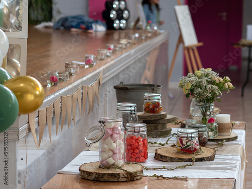 Table de bonbons devant scène pour fête d'enfants avec décoration champêtre
