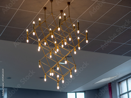 Lustre moderne et doré avec de multiples ampoules et offrant des perspectives cubiques