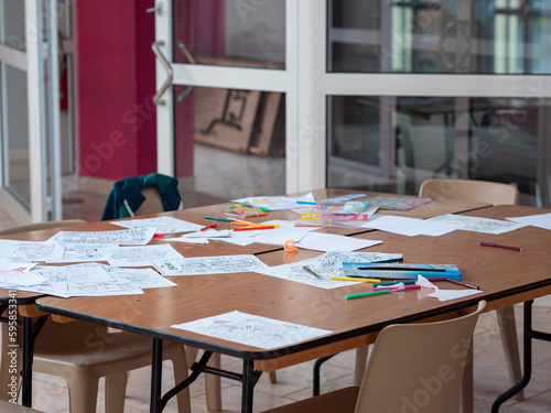 Table en désordre avec dessins d'enfants et feutres