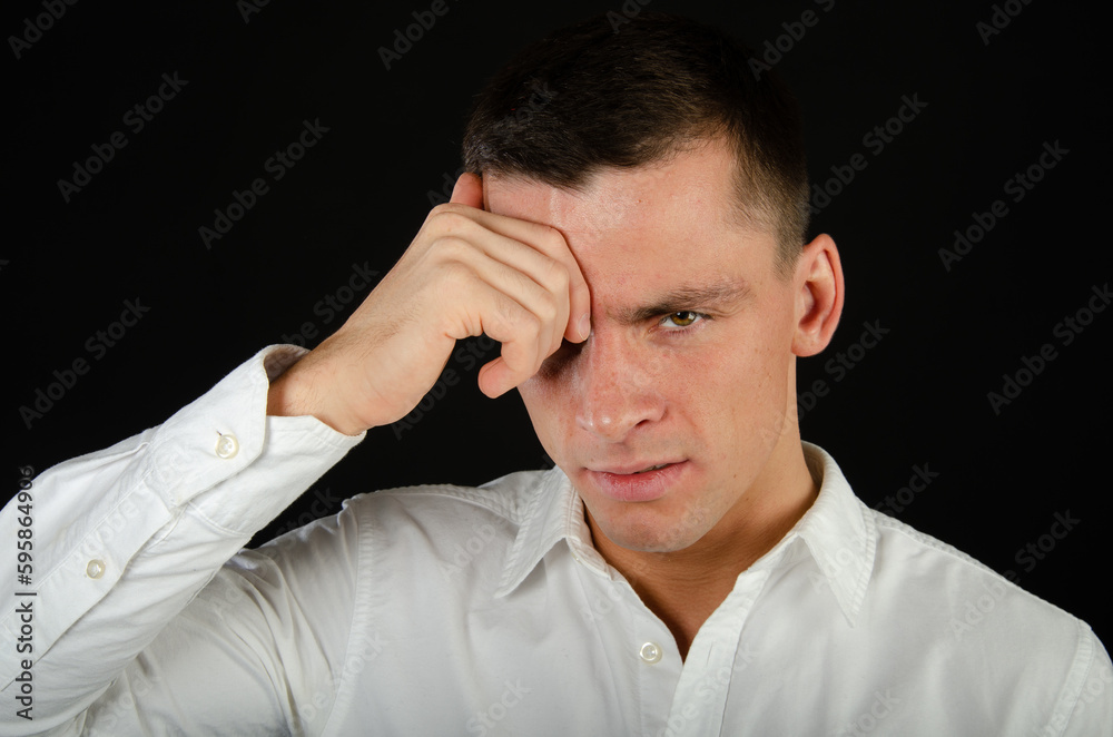 Young attractive man is crying and posing in the studio.