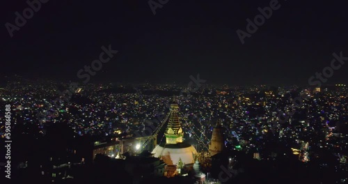 The drone orbits around Swayambhunath Stupa, known as Monkey Temple, showcasing the beauty of Kathmandu at night during Tihar Light festival. A mesmerizing aerial view capturing the essence of Nepal.