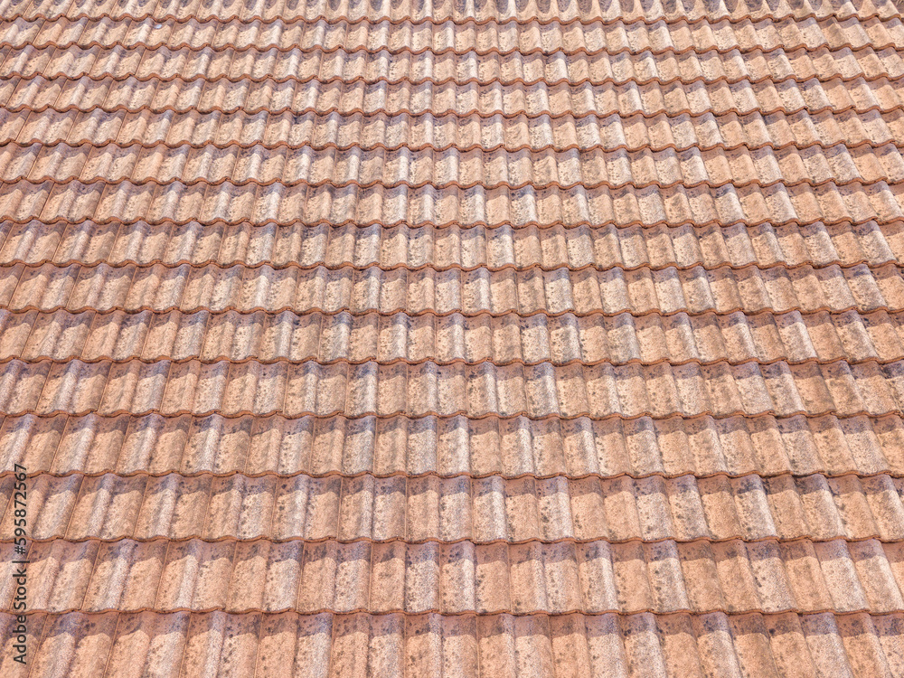 Close up of brown clay roof tiles. Red old dirty roof. Old roof tiles. Construction equipment build a house.