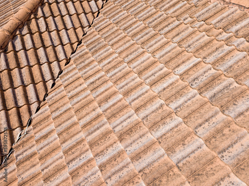 Close up of brown clay roof tiles. Red old dirty roof. Old roof tiles. Construction equipment build a house. Close up of brown clay roof tiles. Red old dirty roof. Old roof tiles. Construction equipment build a house.