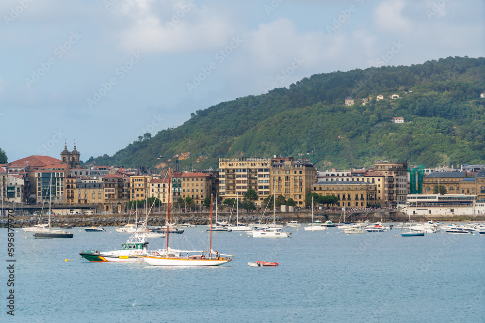 SAN SEBASTIAN, Spain July 08 2022: Beautiful San Sebastian - Donostia city. Situated in north of Spain, Basque Country. Famous travel destination. View of La Concha Bay. People at the beach. 