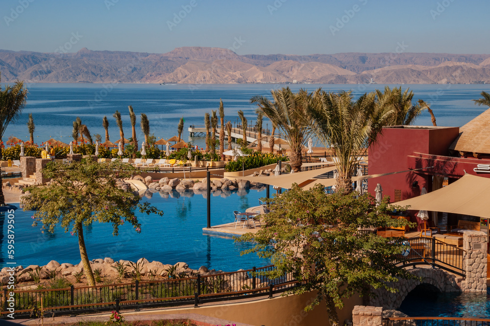 Hotel Movenpick Resort and SPA Tala Bay Aqaba 5 stars on the Red Sea in Jordan. Hotel area with many pools surrounded by palm trees. Aqaba, Jordan - December 06, 2009