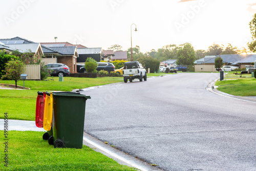 Empty rubbish and recycling bin sitting at bed in suburban road after rain