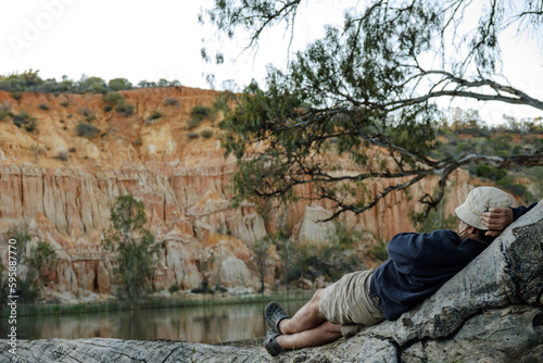 Man relaxing  by the River Murray watching the River boats go by
