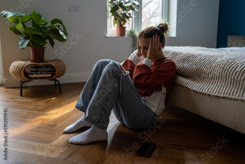 Bilde på lerret Frustrated sad teen girl child sitting alone on floor being bullied online, having feelings of isolation and fear
