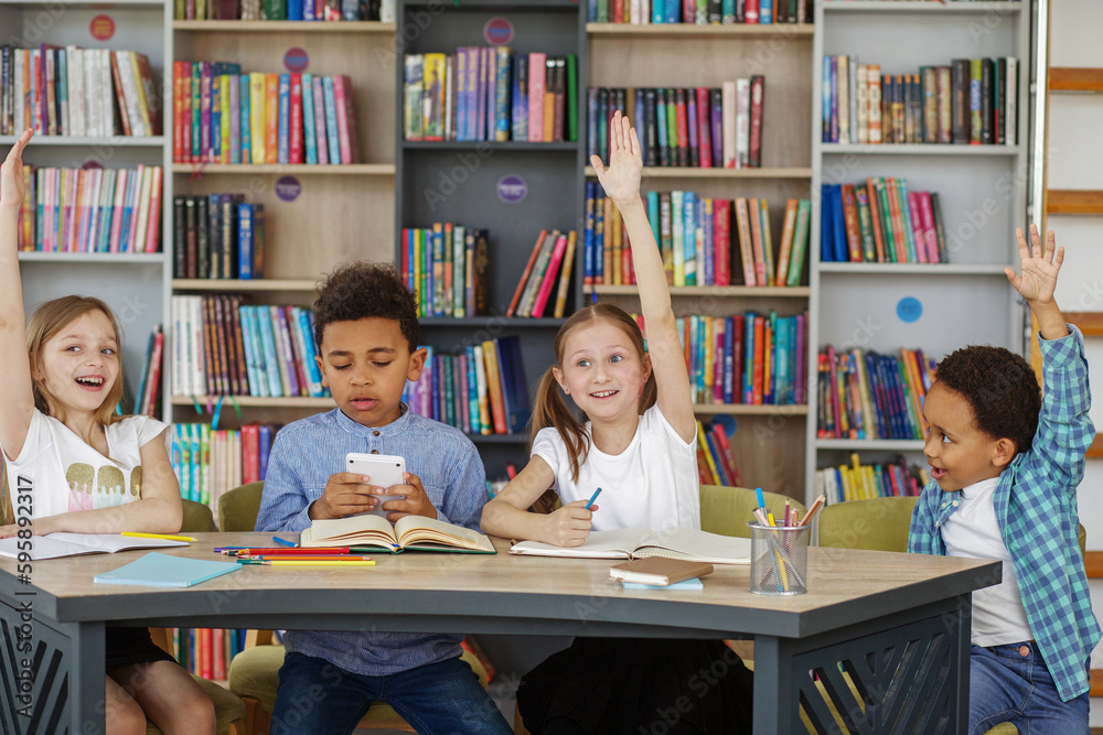 Mixed-race pupils study and write at table in library or classroom. Back to school. Mixed-race pupils study and write at table in library or classroom. Back to school.
