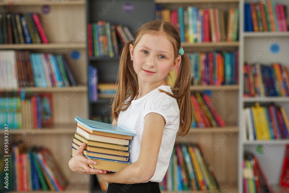 Child buys books in bookstore for learning or reading. Girl choosing book in school library. Child buys books in bookstore for learning or reading. Girl choosing book in school library.
