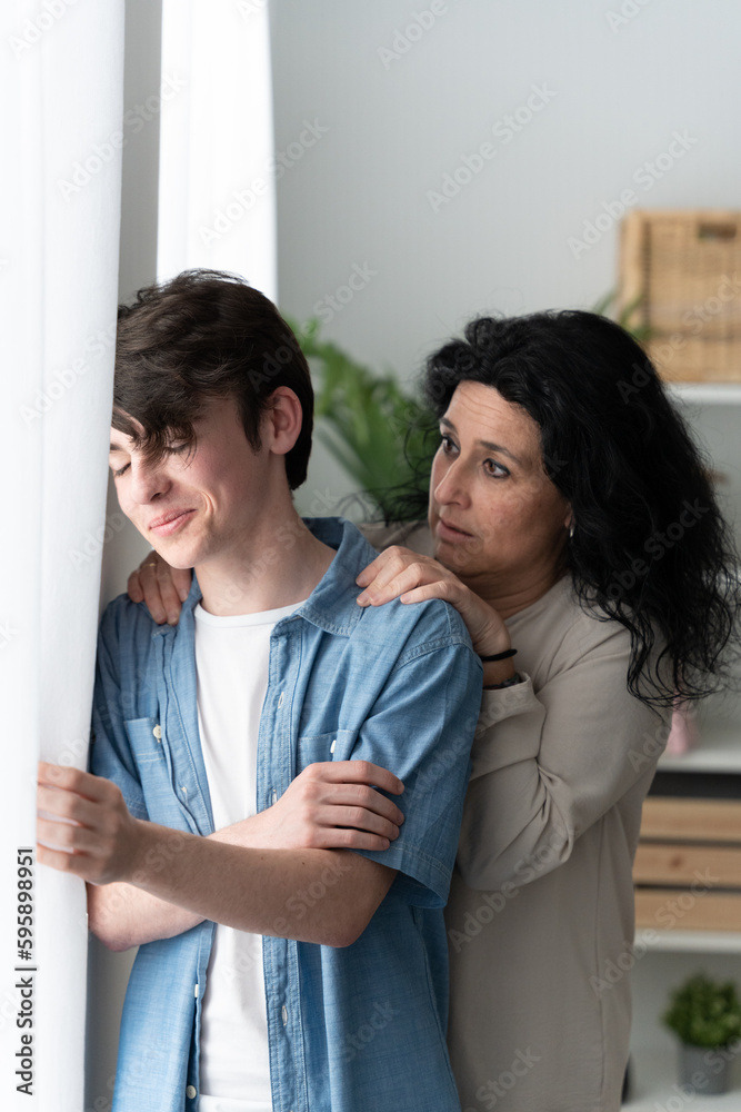 Woman comforting adolescent son at home. Mother asking for forgiveness Woman comforting adolescent son at home. Mother asking for forgiveness