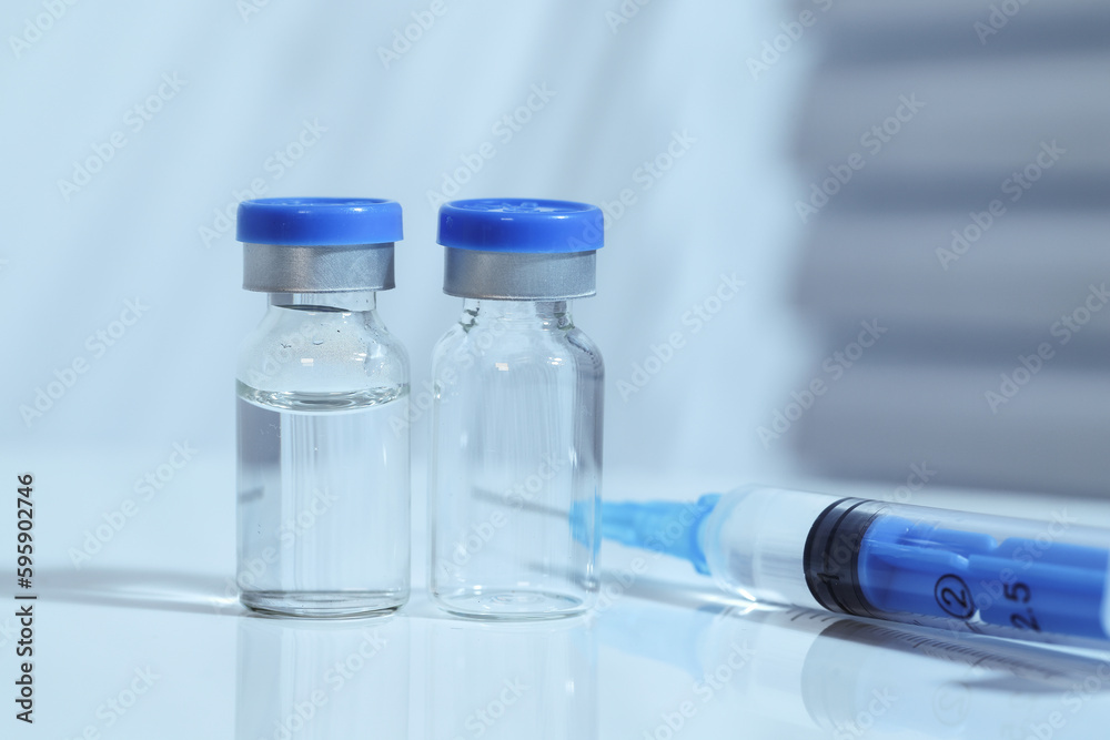 Syringes and vaccines are placed on the table in the medical office, cool toned image, blue color temperature Syringes and vaccines are placed on the table in the medical office, cool toned image, blue color temperature