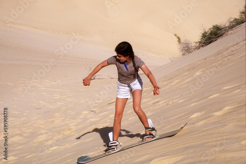 Teenage girl wakeboarding on sand dunes, Mozambique