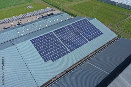 Company,s buildings with solar panels in a row on a roof. 

Photo taken with a drone.

Photovoltaic modules for renewable energy.Save the earth and the energy with good environment concept.
