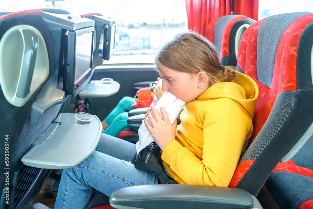 Girl is sick, vomits in bag. Bus road traveling. Girl kid feels bad