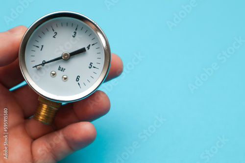 Pressure gauge in hand, measuring instrument close up on pneumatic or hydraulic control system. Hydraulic equipment is used for measuring pressure in the system