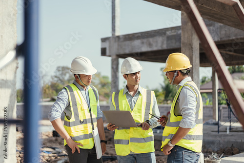 Civil engineer use computer labtop and discussing plan details in construction site. Building project with Civil Engineer,.