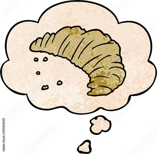 cartoon croissant with thought bubble in grunge texture style