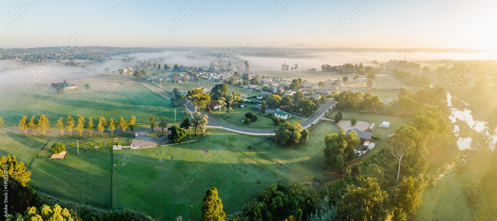© Austockphoto - Warm morning sunlight chasing away fog from hobby farm paddocks near country town
