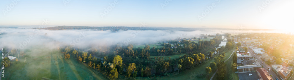 panoramic aerial view of mist over river and farmland beside aussie town at sunrise panoramic aerial view of mist over river and farmland beside aussie town at sunrise