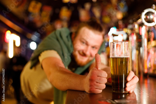 cheerful man in a pub shows him to pour beer