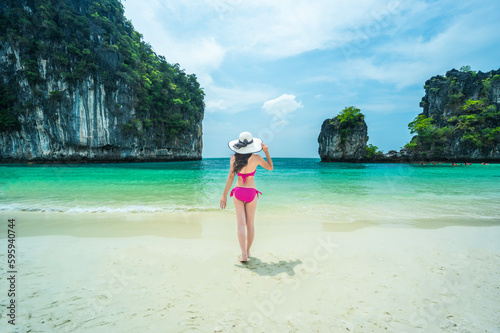 Female tourist wearing bikini on white beach tea, blue green water at Maya Bay, Koh Phi Phi