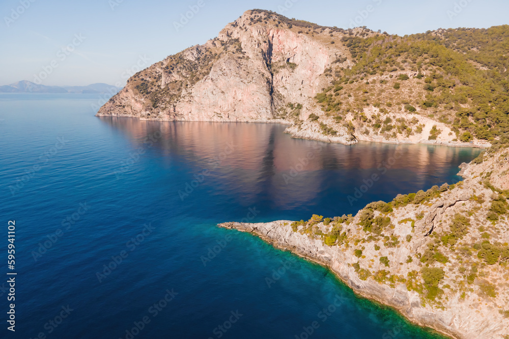 Winding coastline of Aegean seacoast with calm turquoise water in sunny day. Aerial view
