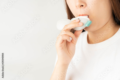 Konstfotografi Young asian woman using Tiotropium bromide asthma inhaler over white background